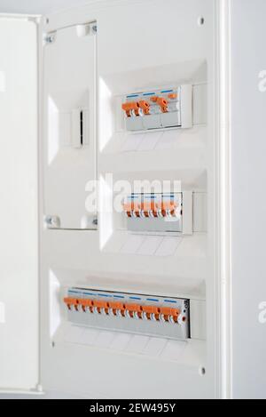 Primo piano: Vista della scheda del pannello di distribuzione bianco verticale montata a parete Foto Stock
