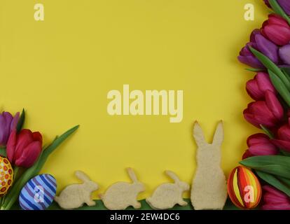 tulipani, primrosi, uova dipinte e biscotti a forma di coniglietto Foto Stock