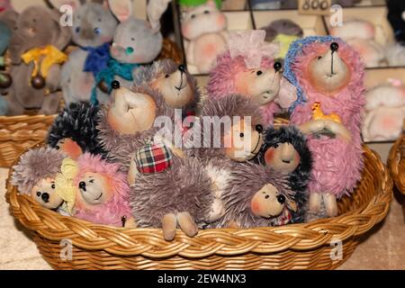 Ci sono molti giocattoli hedgehog nel cestino di vimini. Animali carini e divertenti Foto Stock