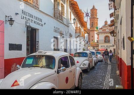 White Volkswagen Beetle taxi in una strada stretta nel centro coloniale della città di Taxco de Alarcón, Guerrero, Messico Foto Stock