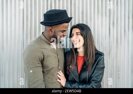 Coppia di etnicità mista alla moda che pende l'una sull'altra Foto Stock