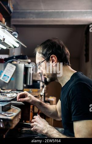 Foto di stock di uomo concentrato che lavora con utensili in artigianato officina Foto Stock