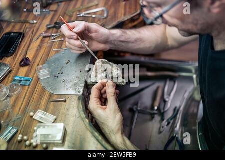 Foto di stock di uomo concentrato che lavora con utensili in artigianato officina Foto Stock