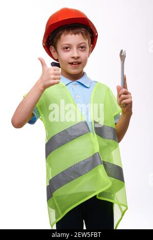 Giubbotto da costruzione bambini in età prescolare con chiave per casco arancione e. pollice su gesturing su sfondo bianco isolato Foto Stock