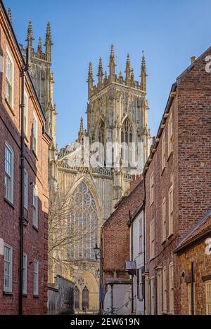Ad ovest le torri della cattedrale di York Minster innalzarsi al di sopra delle case di una strada vicina. Foto Stock