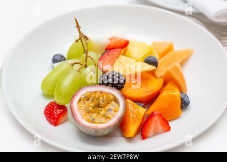 Piatto di frutta fresca a fette per colazione. Su una piastra bianca, passionfruit, Foto Stock