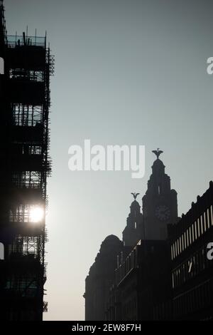 Torri del Royal Liver Building con uccelli di fegato set Contro il sole che tramonta a Pier Head a Liverpool Foto Stock