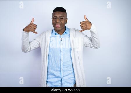 Giovane bell'uomo afro-americano che indossa abiti casual con cui gridare espressione pazzesca facendo rock simbolo con le mani in su Foto Stock
