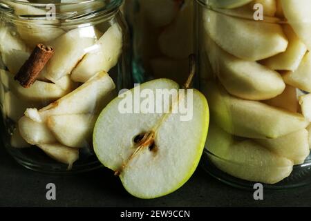 Closeup shot di vasetti trasparenti in vetro riempiti con fette di pera sbucciata matura Foto Stock