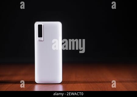 power bank bianco per caricare i dispositivi mobili su sfondo nero Foto Stock