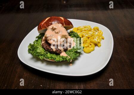 Delizioso cheeseburger con tutti i fissaggi su un panino Foto Stock