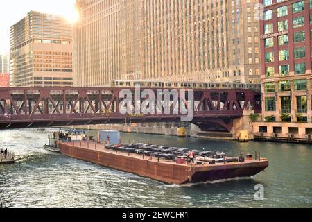 Chicago, Illinois, Stati Uniti. Il sole tramonta dietro il Merchandise Mart di Chicago e il traffico affollato sopra e sul fiume Chicago. Foto Stock