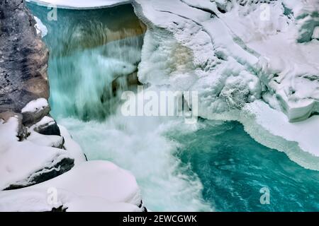Un'immagine orizzontale dell'Athabasca cade sul fiume Athabasca in inverno con le cicale congelate aggrappate alle pareti del canyon roccioso in Jasper National Pa Foto Stock
