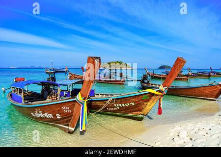 Pesca tradizionale a coda lunga e barche turistiche su Sunrise Beach, Isola di Koh Lipe, Thailandia, con cielo blu Foto Stock