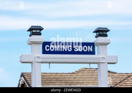 In arrivo segno di fronte a una casa in vendita in un quartiere residenziale. Foto Stock