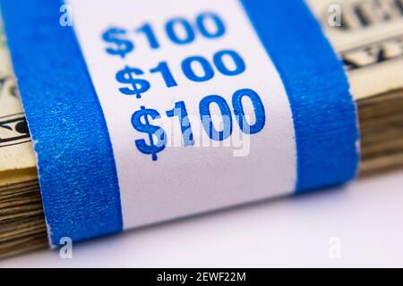 100 dollari di carta valuta cinghia su pila di soldi degli Stati Uniti. Messa a fuoco selettiva. Foto Stock