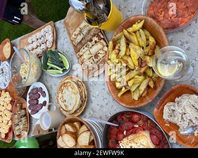 Dall'alto di vari tipi di spuntini e piatti fatti in casa servita su un tavolo rustico durante la festa estiva all'aperto Foto Stock