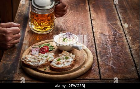 Dall'alto della persona anonima di raccolto con tazza di alcolico fette di bevanda e sale su pezzetti di pane di segale Foto Stock