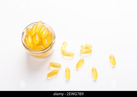 Omega 3 capsule in vaso di vetro su sfondo bianco olio di pesce softgels gialli Vitamina D, e, UN concetto di supplemento di sanità Copia spazio fuoco selettivo Foto Stock