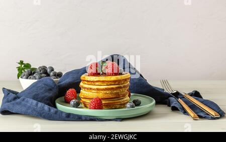 Gustosi pancake americani con lamponi, mirtilli e miele. Foto Stock