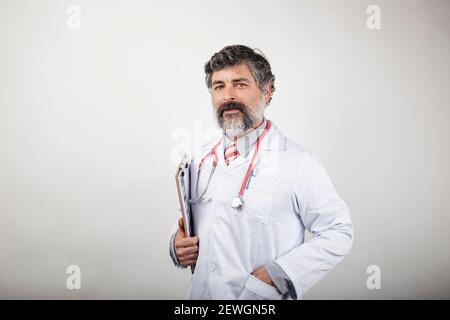 ritratto del medico con appunti e stetoscopio su sfondo bianco Foto Stock