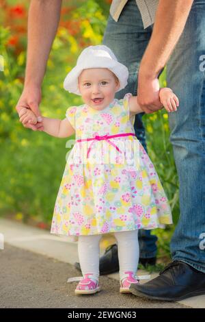 Ritratto di una bella bambina che si diverte in campo di fiori in primavera. Bella bambina sorridente. Foto Stock