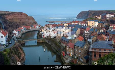 STAITHES, NORTH YORKSHIRE, UK - 16 MARZO 2010: Vista del Roxy beck, villaggio e porto al tramonto Foto Stock