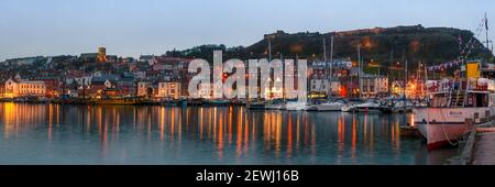 SCARBOROUGH, NORTH YORKSHIRE, UK - 19 MARZO 2010: Vista panoramica sul porto di notte con il Castello sulla collina dietro la città Foto Stock