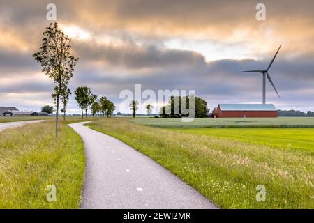 Terreni agricoli moderni con campi, mulini a vento e fienili nel paesaggio agricolo della provincia di Groningen, Paesi Bassi. Foto Stock