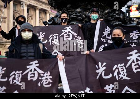 Londra, Regno Unito. 1 marzo 2021. I sostenitori di Hong Kong che detengono bandiere di protesta vietate hanno letto 'liberare Hong Kong, la rivoluzione del nostro tempo'' a Piccadilly Circus, Londra, Regno Unito il 01 marzo 2021. Circa 50 sostenitori di Hong Kong si riuniscono a Piccadilly Circus a Londra per esprimere solidarietà nel sostenere i 47 attivisti pro-democrazia di Hong Kong che aiutano e gestiscono le elezioni primarie lo scorso anno sono accusati di cospirazione per sovvertire il potere statale in base alla legge sulla sicurezza nazionale partecipare alla loro prima audizione in tribunale Hong Kong il 01 marzo 2021 HK Time. Credit: May James/ZUMA Wire/Alamy Live News Foto Stock