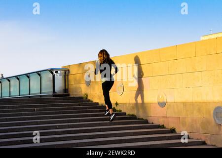 Foto a tutta lunghezza di donna sana che sale sulle scale. Foto Stock