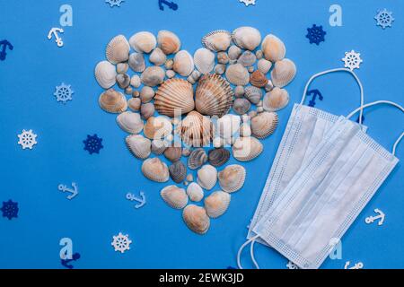 conchiglie a forma di cuore su sfondo blu. Maschere mediche. Acciughe e scortesi. Layout Foto Stock