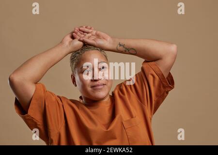 Ritratto di donna spensierata dai capelli corti che si pone contro sfondo neutro in studio, copia spazio Foto Stock