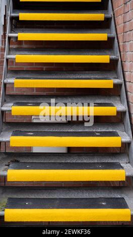 Esterno, scala in metallo con gradini antiscivolo gialli a Westbury, Wiltshire, Inghilterra, Regno Unito. Foto Stock