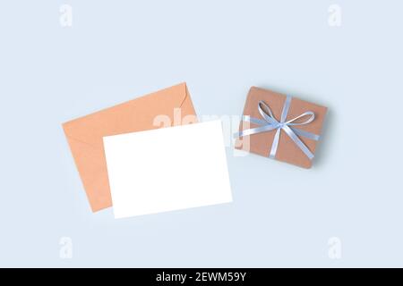 Busta, mockup di carta vuoto e confezione regalo su sfondo blu pastello. Presente e lettera per la Giornata dei Padri. Foto Stock