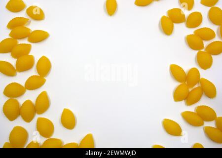 Vermicelli italiani gialli secchi, pasta fatta da conchiglie Wwkushi di varietà a grani solidi si trovano su uno sfondo bianco. Foto Stock