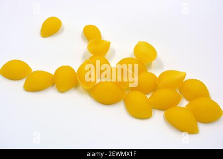 Vermicelli italiani gialli secchi, pasta fatta da conchiglie Wwkushi di varietà a grani solidi si trovano su uno sfondo bianco. Foto Stock