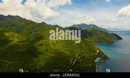 Mare aereo: La costa dell'isola di Leyte con colline e montagne coperte di verde foresta e giungla. Filippine. Foto Stock