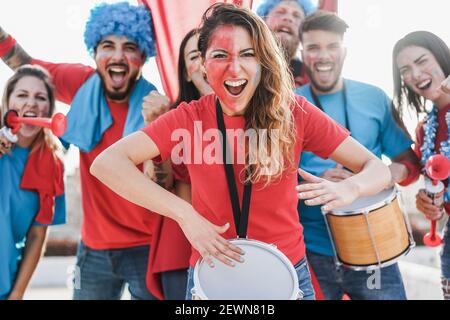 Fan di sport pazzi che suonano la batteria e gridano mentre sostengono il loro Team - Focus sulla donna del centro Foto Stock