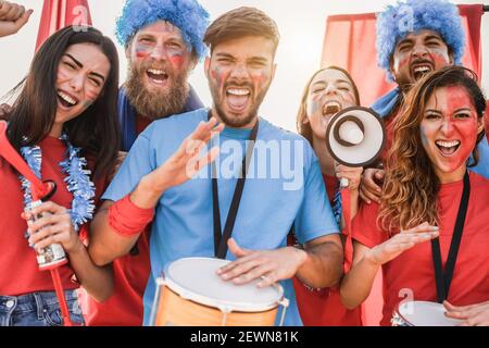 Fan di sport pazzi che suonano la batteria e gridano mentre sostengono il loro team Foto Stock