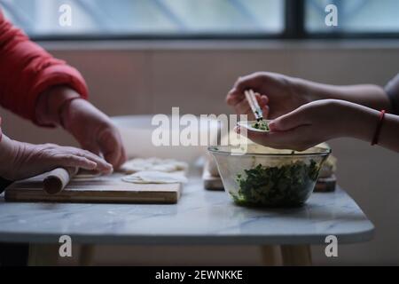 primo piano persone che fanno gnocchi. Cibo cinese tradizionale durante il nuovo anno cinese. Concetto di cultura cinese Foto Stock