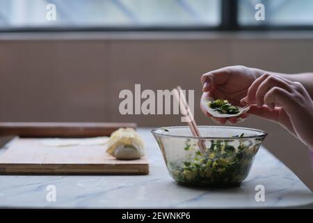 primo piano di fabbricazione manuale gnocchi. Cibo cinese tradizionale durante il nuovo anno cinese. Concetto di cultura cinese Foto Stock