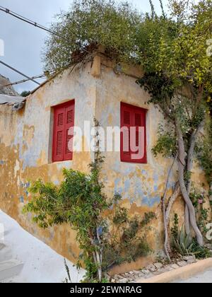 Muro colorato invecchiato di una vecchia casa nel pittoresco quartiere di Anafiotika, a Plaka, la città vecchia di Atene, capitale della Grecia, Europa Foto Stock
