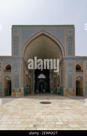 Yazd, Iran - 13.04.2019: Cortile della storica Moschea Jameh di Yazd con le sue piastrelle esagonali e turchesi. Persone che camminano nel cortile di Shia Foto Stock