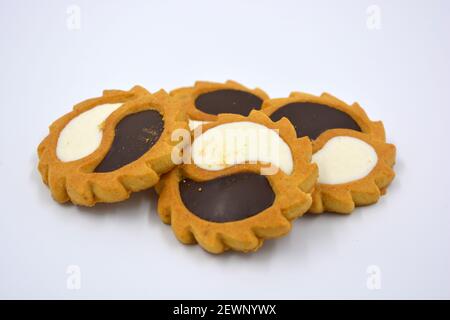 Biscotto di sicurezza sotto forma di sole con stucco bianco e cioccolato, dolce sotto forma di due gocce poste su fondo bianco. Foto Stock