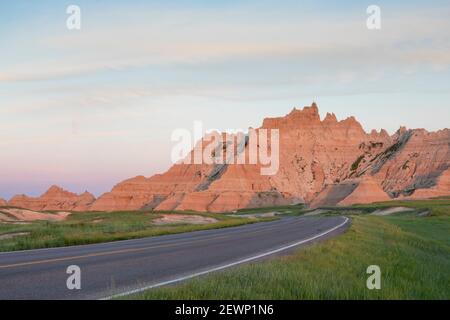 Strada vuota attraverso il Parco Nazionale di Badlands in leggera luce notturna. Foto Stock