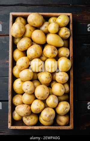 Patate del bambino piccolo patate rotonde dall'india insieme, in scatola di legno, su sfondo vecchio tavolo di legno scuro, vista dall'alto piatto Foto Stock