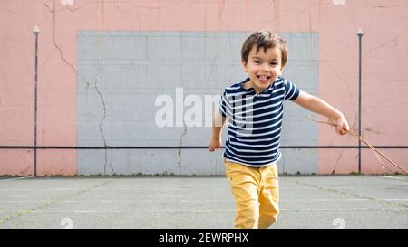 Ragazzino che corre verso la macchina fotografica sul campo basco pelota Foto Stock