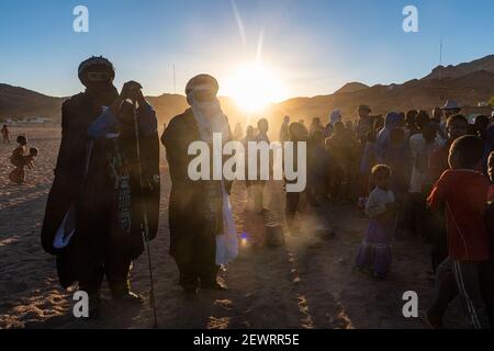 Retroilluminazione di una folla di bambini e uomini Tuareg, Oasi di Timia, Air Mountains, Niger, Africa