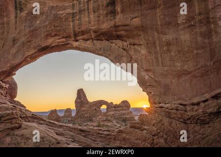 Vista del tramonto e del Turret Arch attraverso Windows Arch, Arches National Park, Utah, Stati Uniti d'America, Nord America Foto Stock